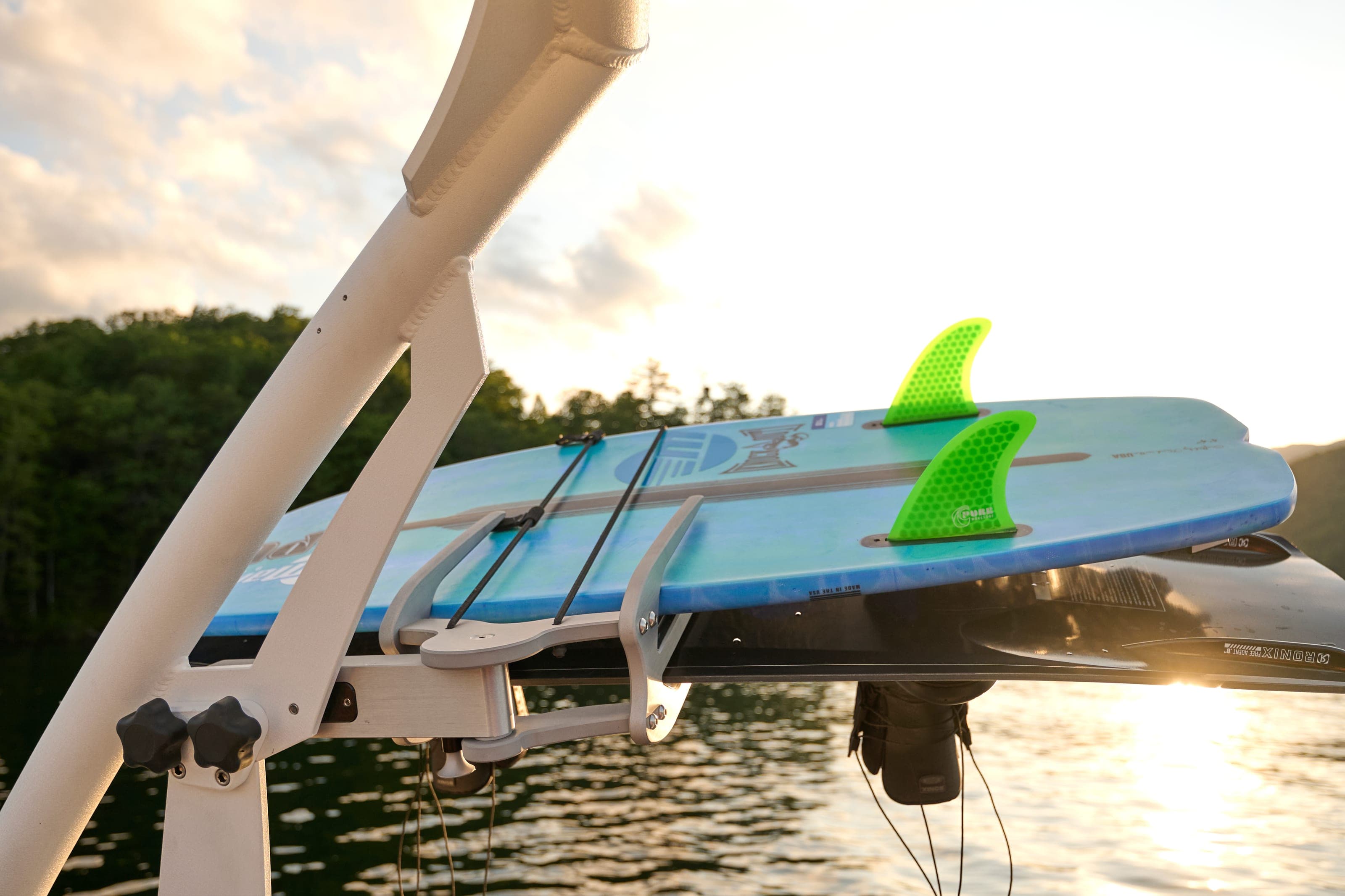 A surfboard in the tower rack of a Malibu 20 VTX at sunset