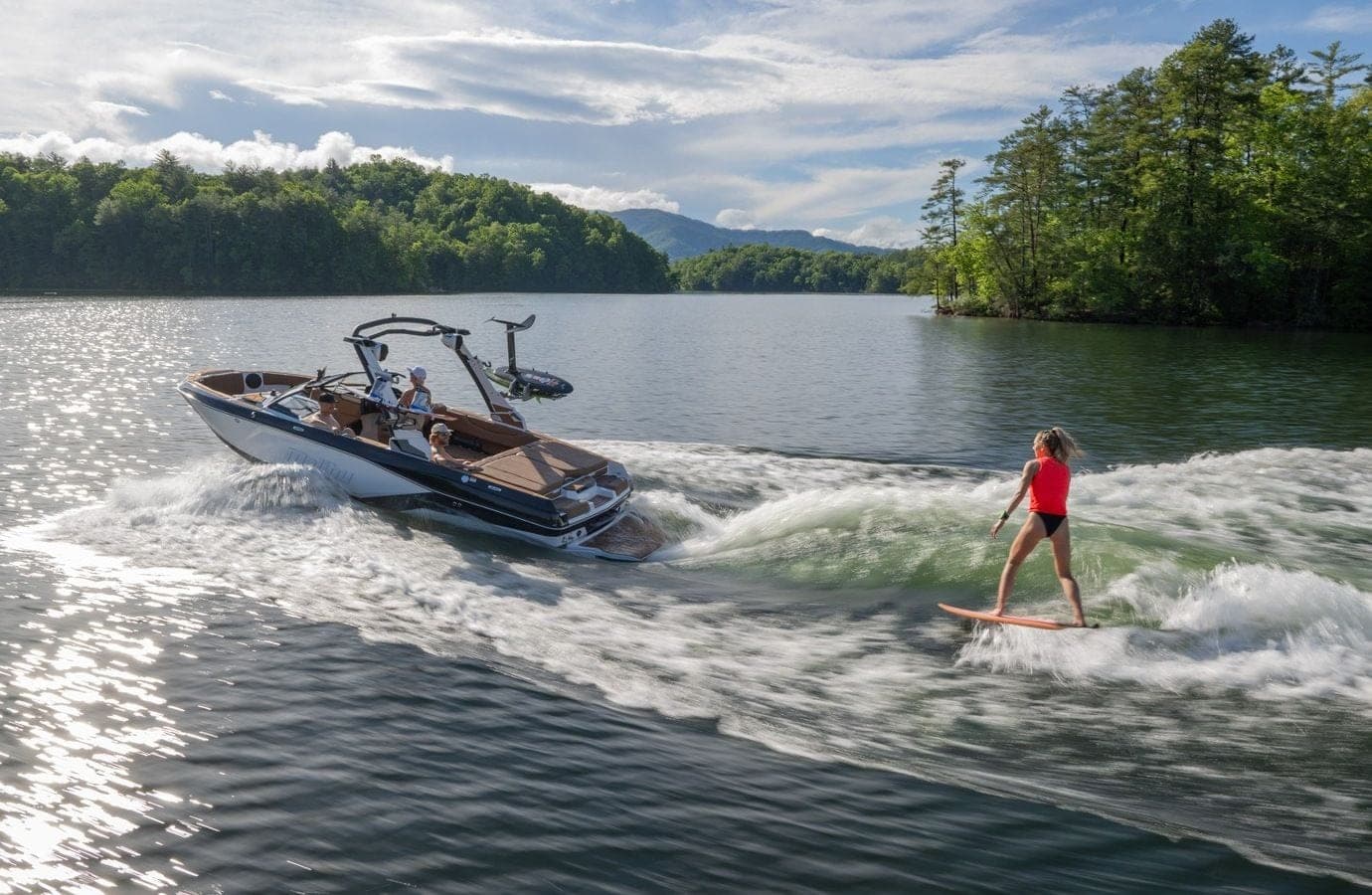 A surfer behind a Malibu 21 LX