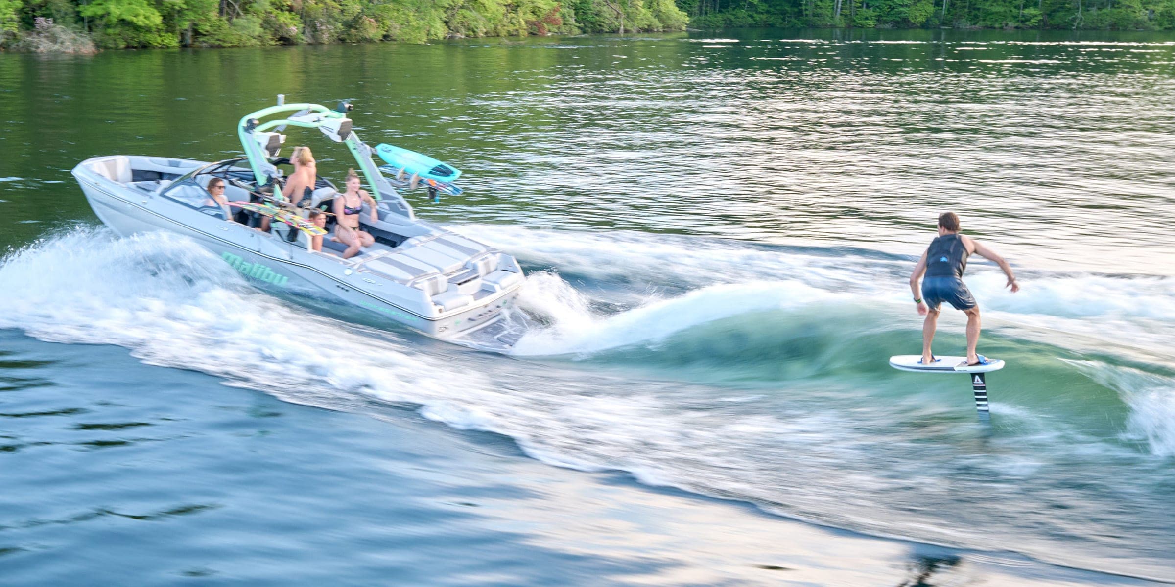 A Malibu 22 LSV at speed with a foil rider in its wake