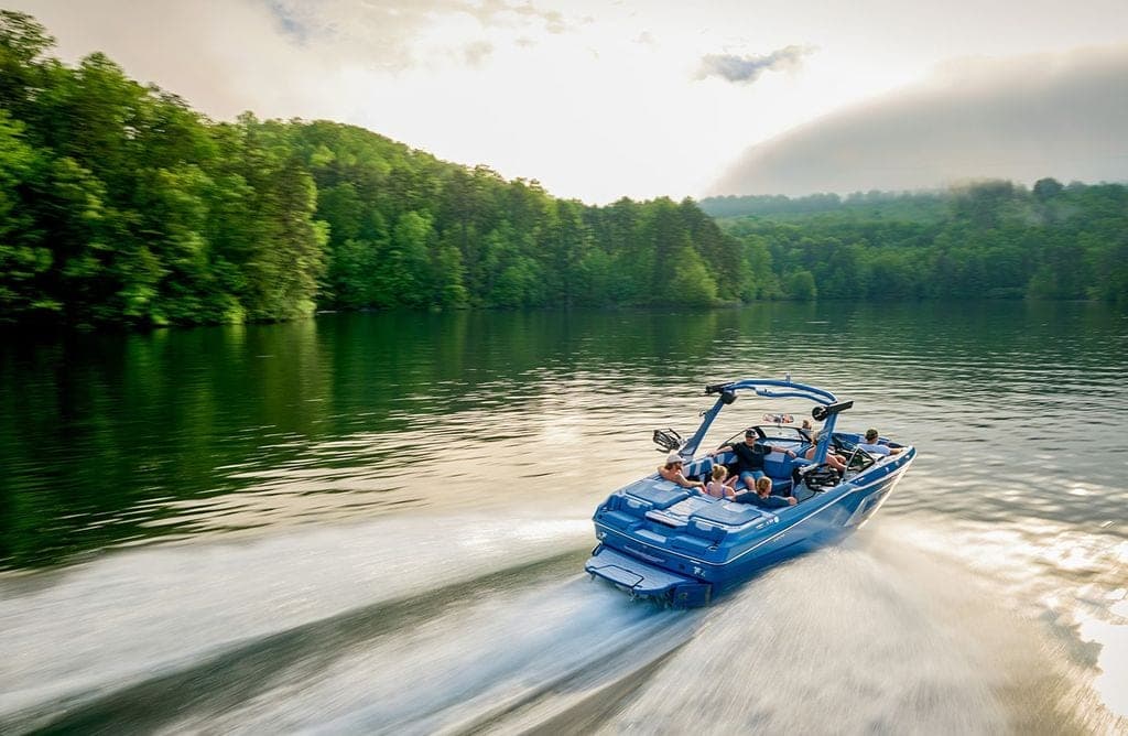 A Malibu 22 MXZ running across a still morning lake