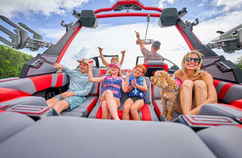 A family in the bow of a Malibu 23 MXZ
