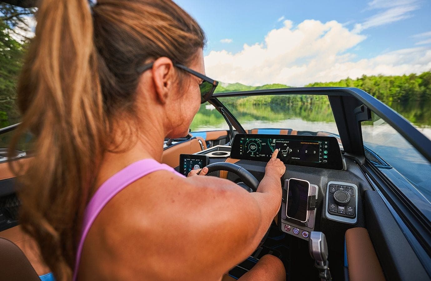 The helm and touchscreens of a Malibu 24 MXZ