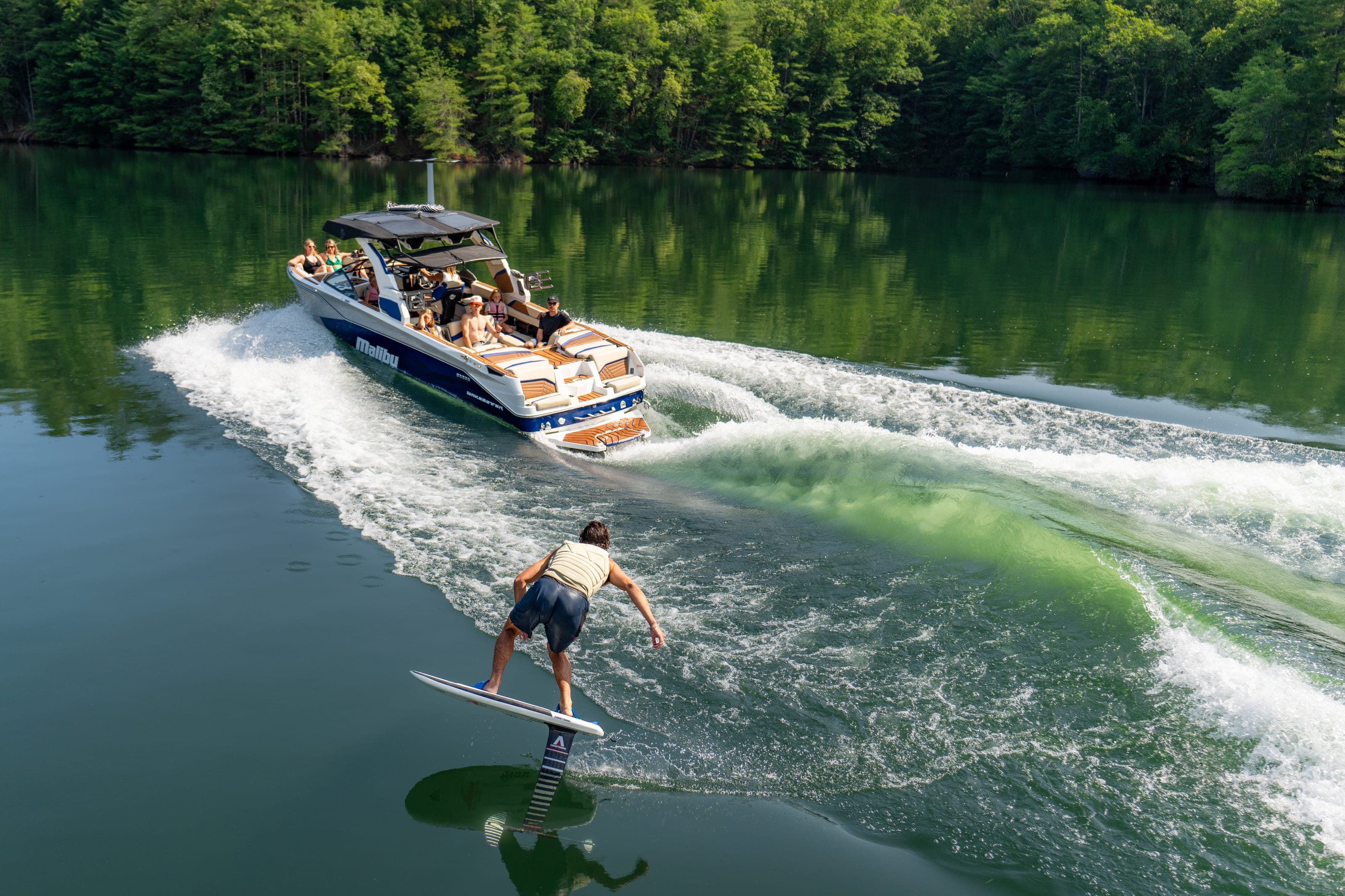 A rider surfs behind a Malibu 26 LSV, seen from above