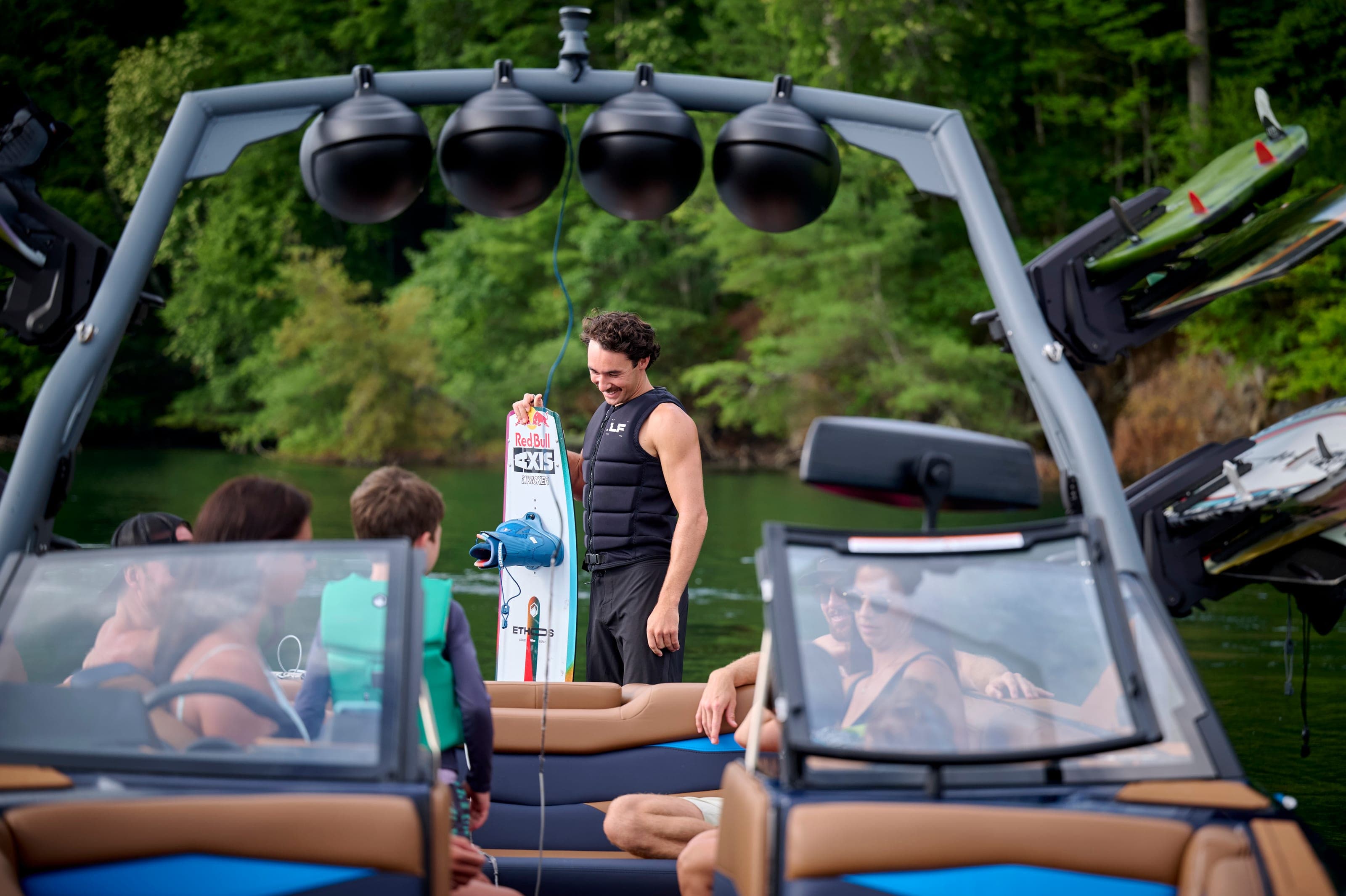 The tower of an Axis A245 with speakers and a wakeboard, people below