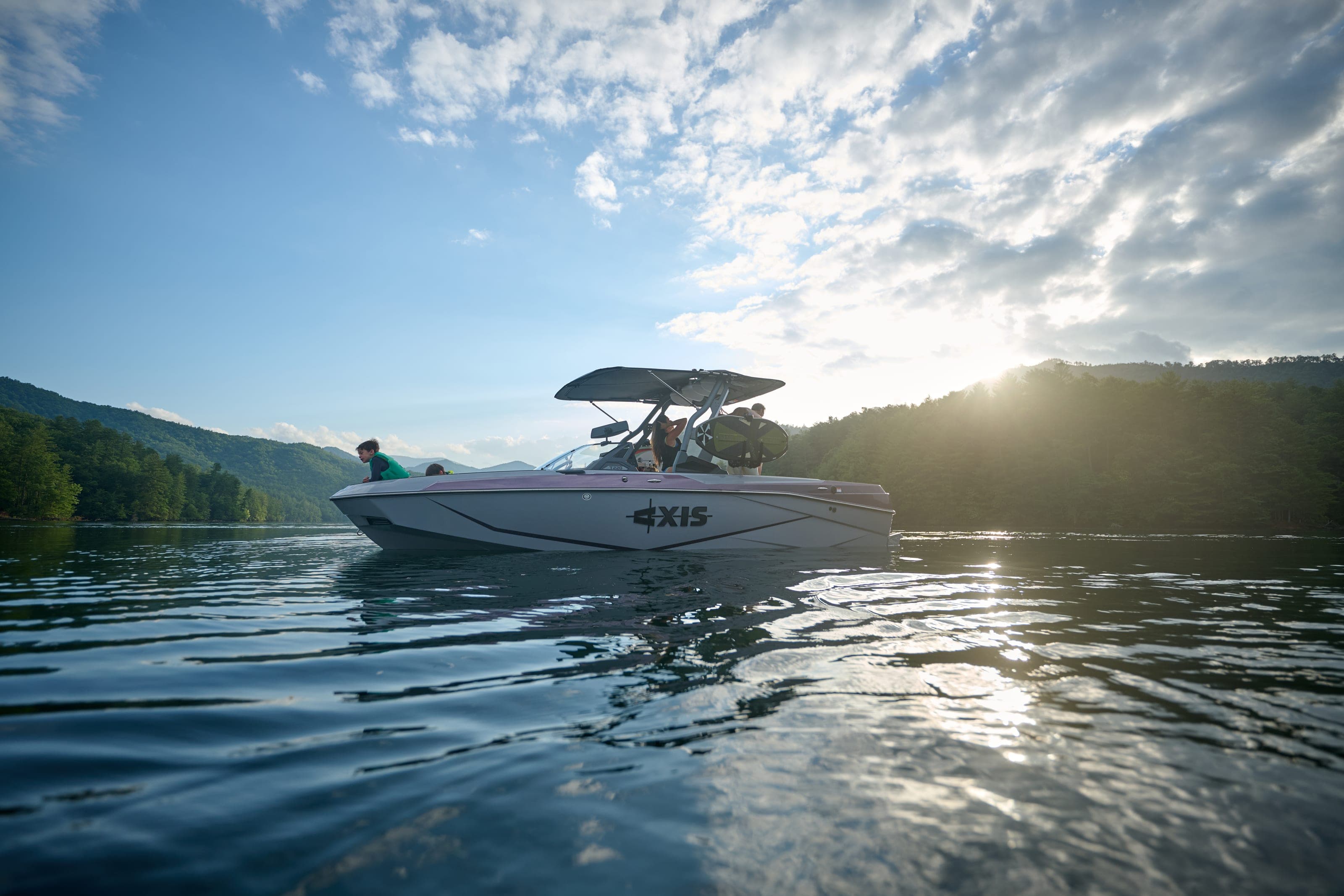 An Axis T220 on calm water with the sun low over the hills