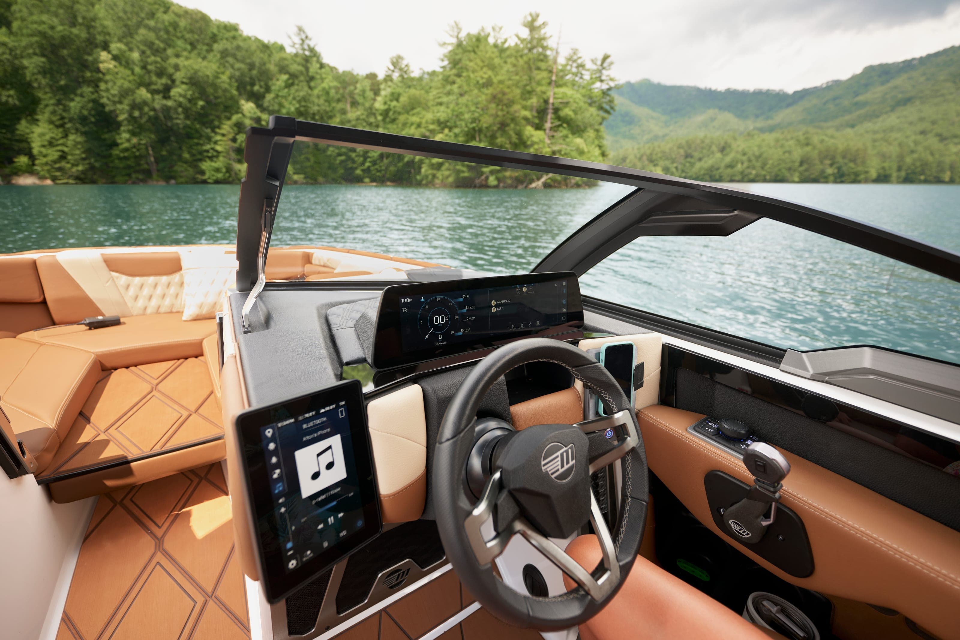The helm of a Malibu M230 with its steering wheel and two screens