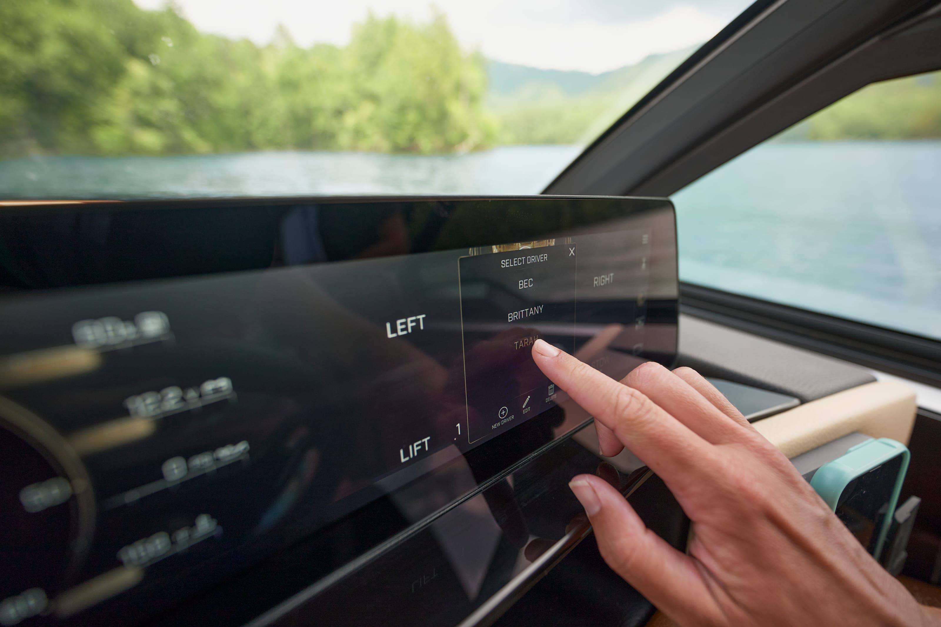 A finger adjusts a setting on the touchscreen of a Malibu M230
