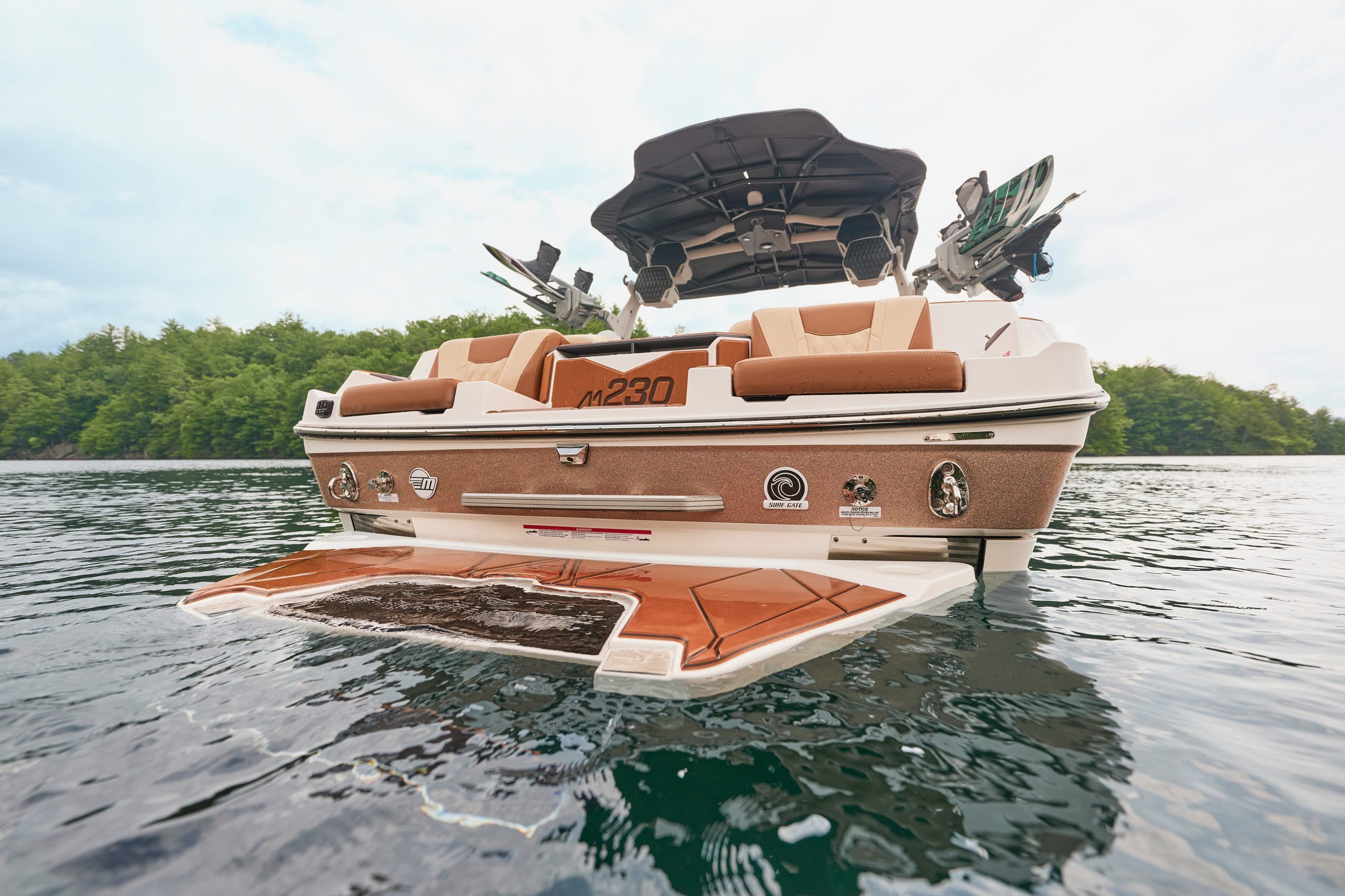 The stern of a Malibu M230 at rest, swim platform lowered and boards in the tower racks