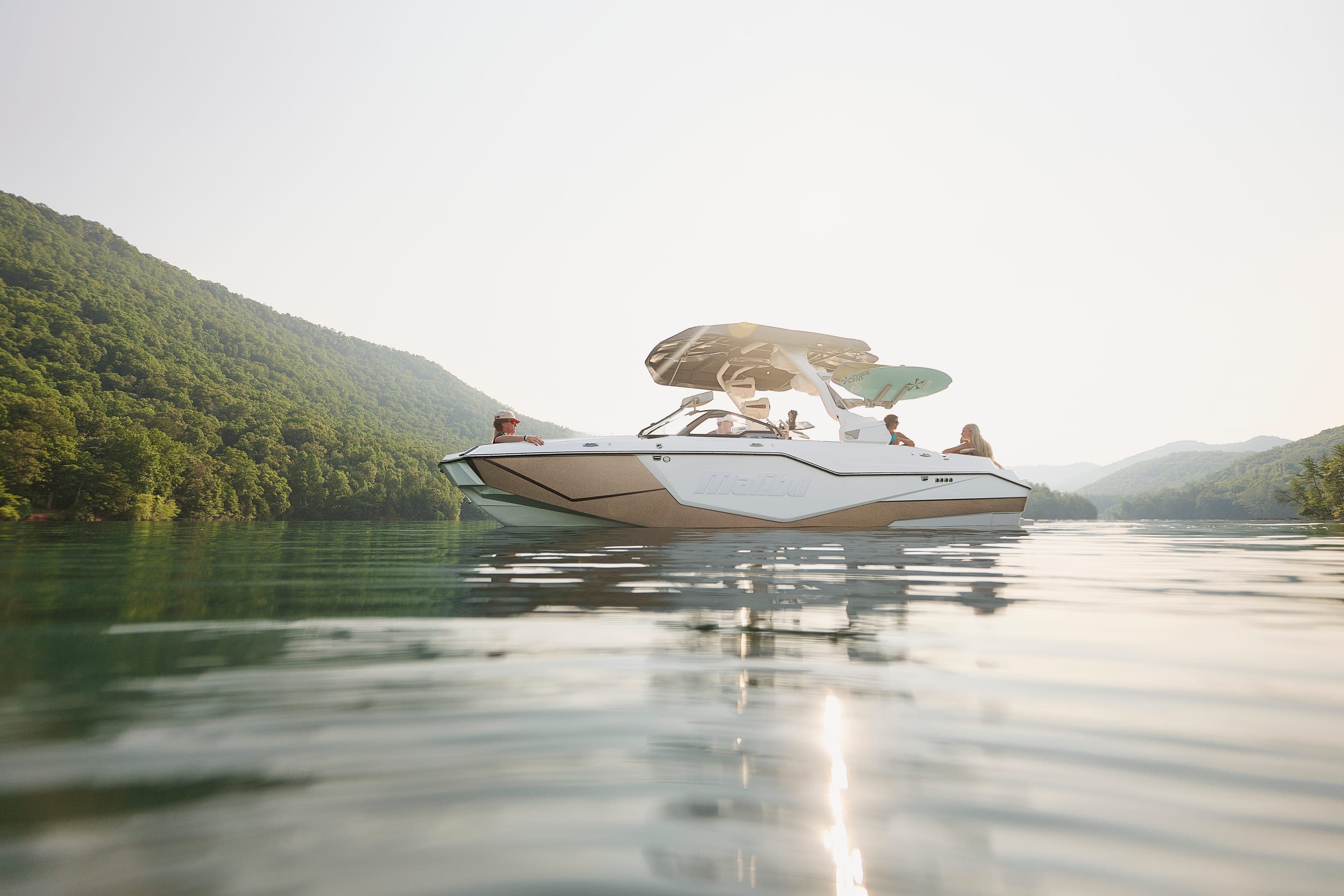 A Malibu M230 at rest on still water, seen from water level