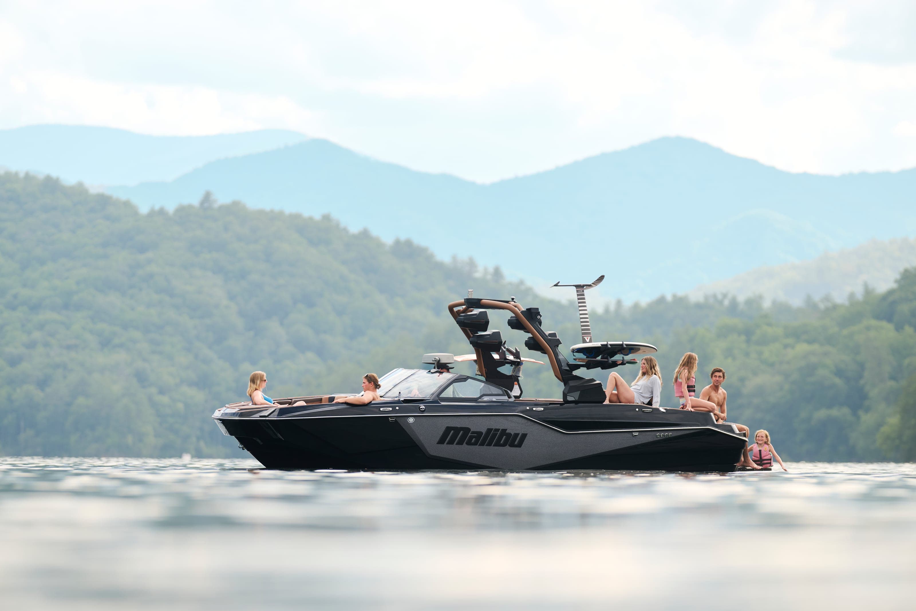 A Malibu M242 at rest, people sitting on the stern