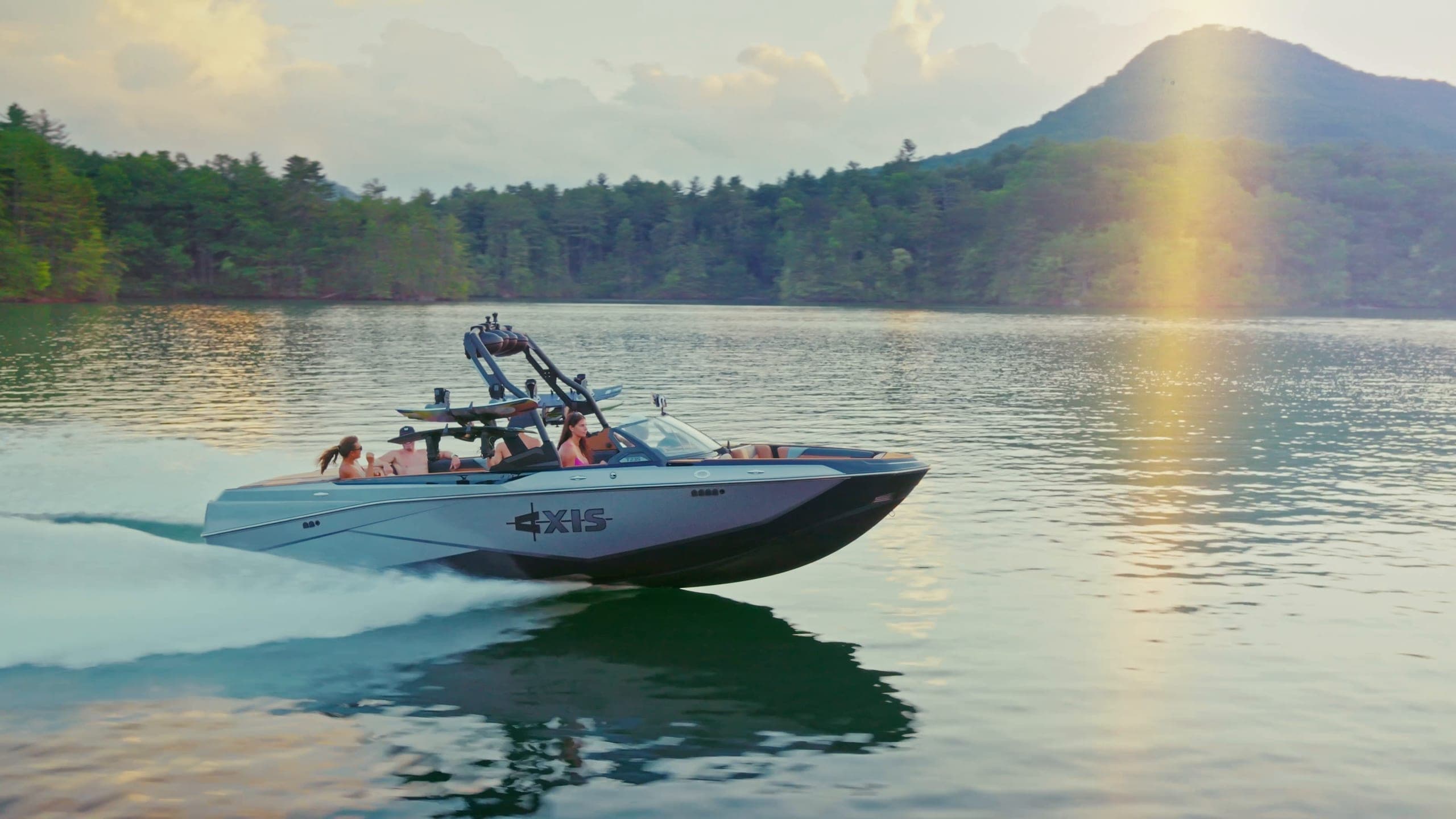 An Axis T235 at rest and at speed, with a wakeboarder and a surfer riding behind it