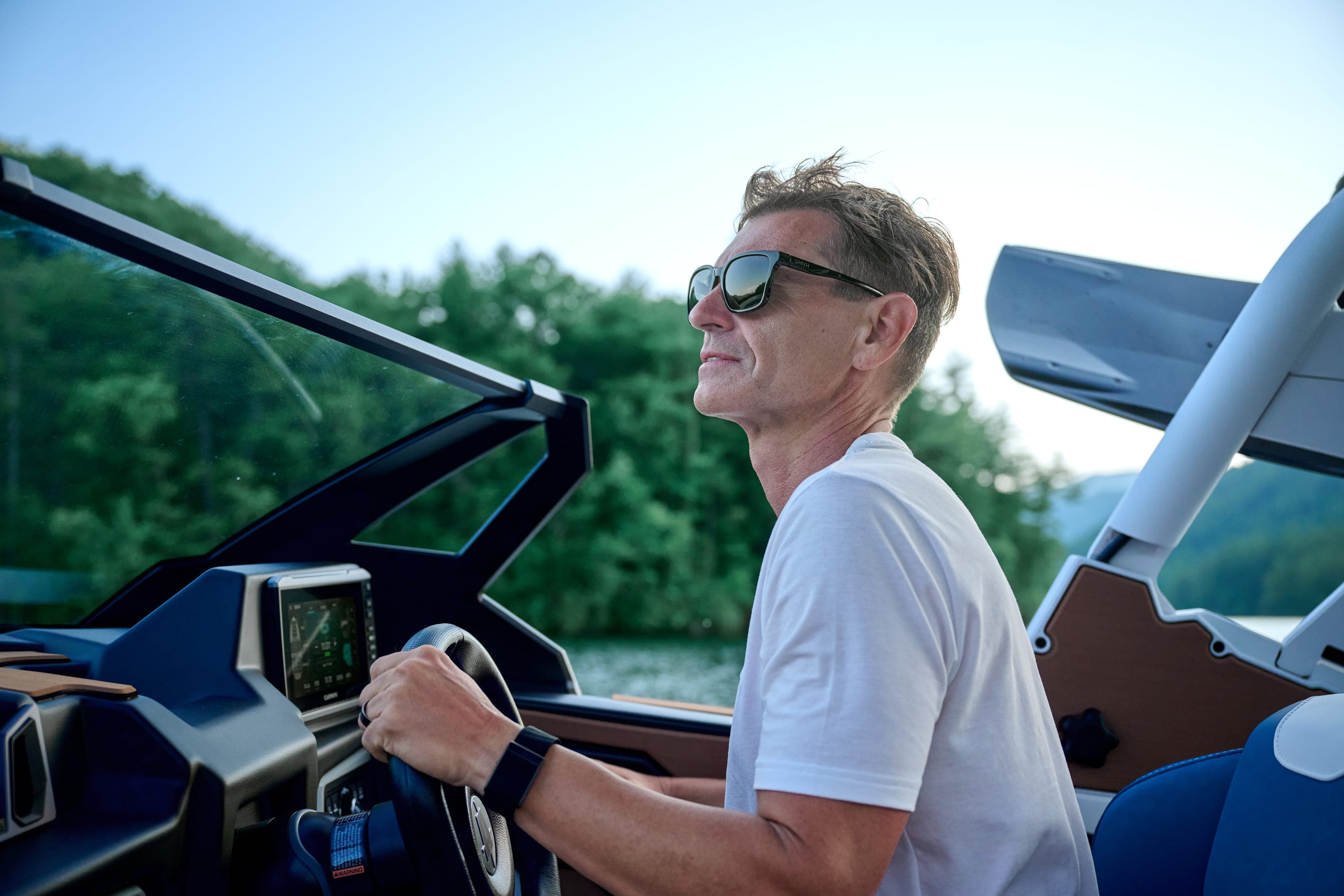 A man in sunglasses at the helm of an Axis A245