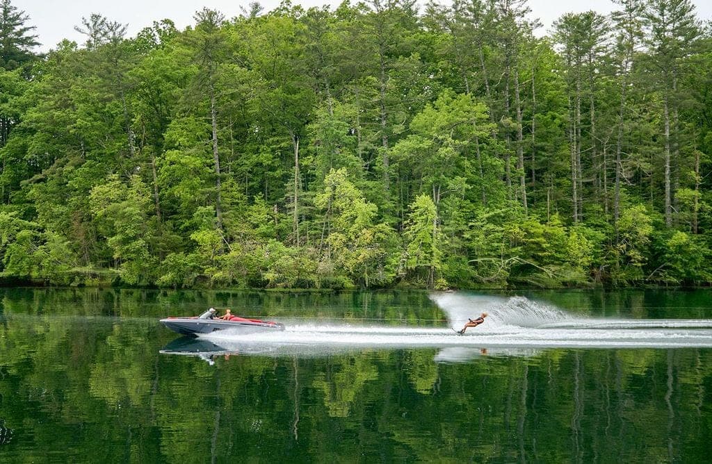 A Malibu Response TXi and a skier on a wooded lake